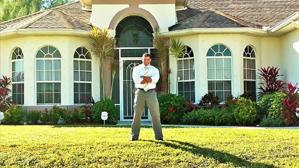 Proud homeowner in front of his property