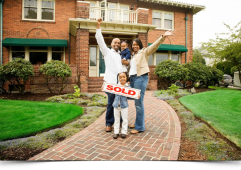 Happy family after selling the house holding a SOLD sign