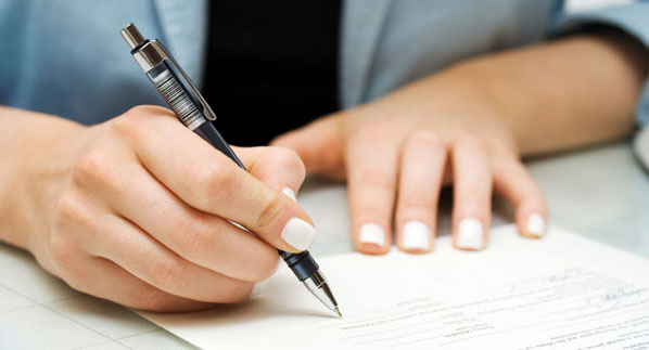 Woman Signing a Forebearance Agreement to Avoid Foreclosure