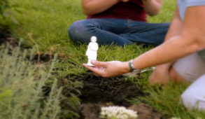 Woman burying a miniature statue of Saint Joseph