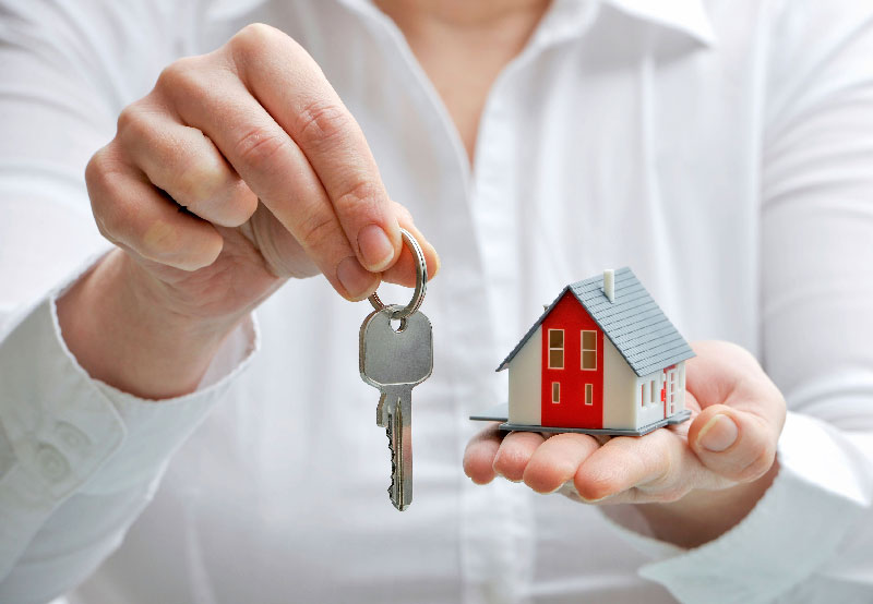 Woman giving model house and keys.