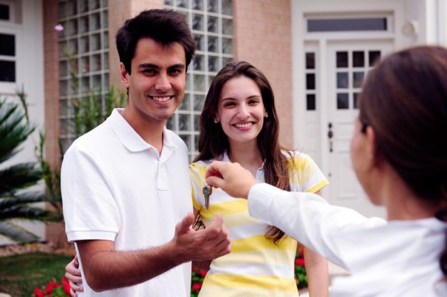 Couple receiving keys from home owner