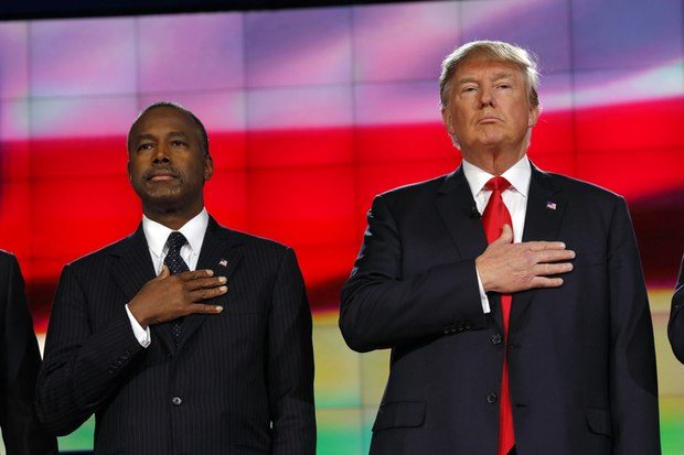 Prsident Elect Donald Trump and neurosurgeon Ben Carson hold hand over heart